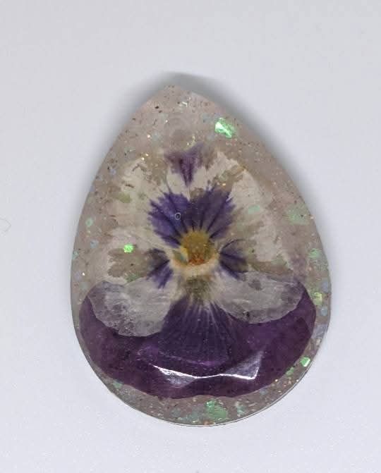 pale epoxy piece with a flower in the middle