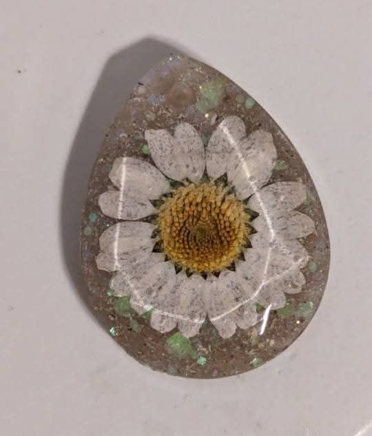 tan epoxy piece with a daisy in the middle